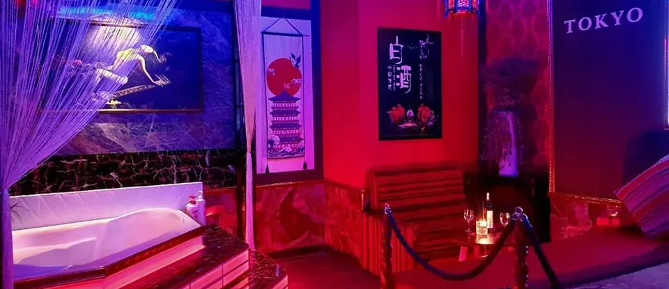紅色 燈光下 按摩浴缸與 設有床的 日式 按摩房