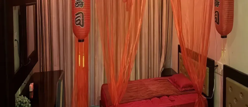 紅色 床品與 橘色 設有等的 臥室