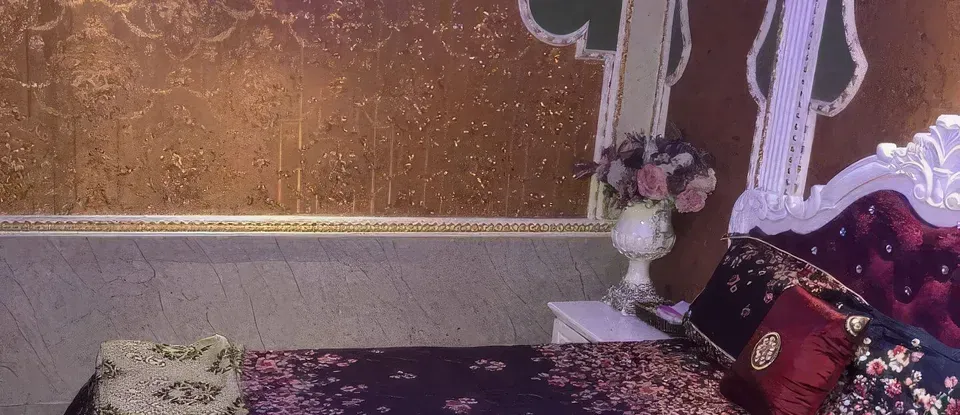 金色 牆與 花卉圖案 設有床的 房間