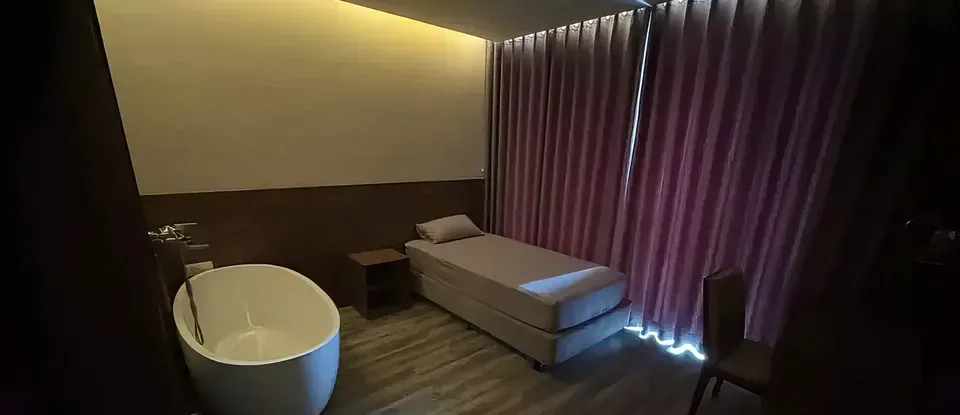 床 旁邊 設有浴缸的 按摩房
